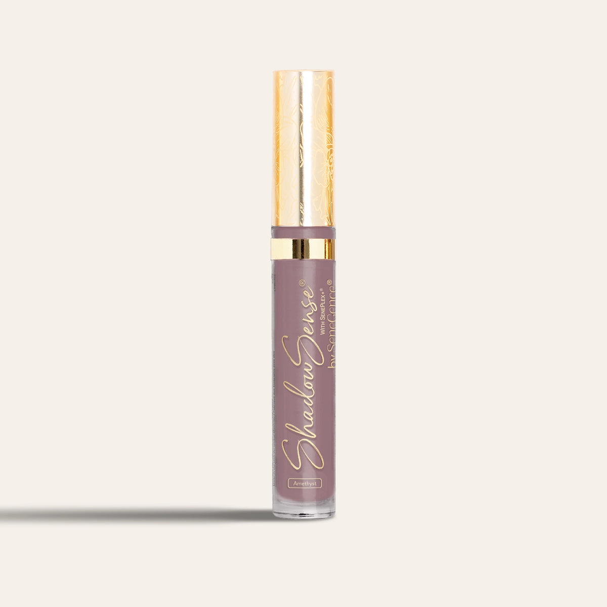 A mauve eyeshadow tube with a gold cap, ShadowSense® Eyeshadow.