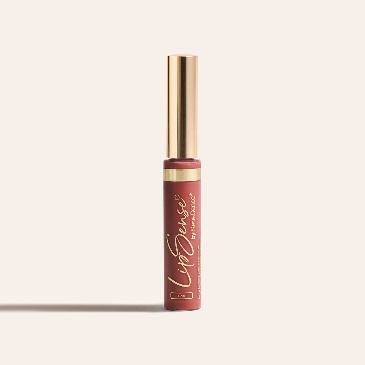 LipSense® Long-Lasting Liquid Lip Color by SeneGence: a brick-rose Chai liquid lip-color tube with a smooth gold cap and a thin gold band.