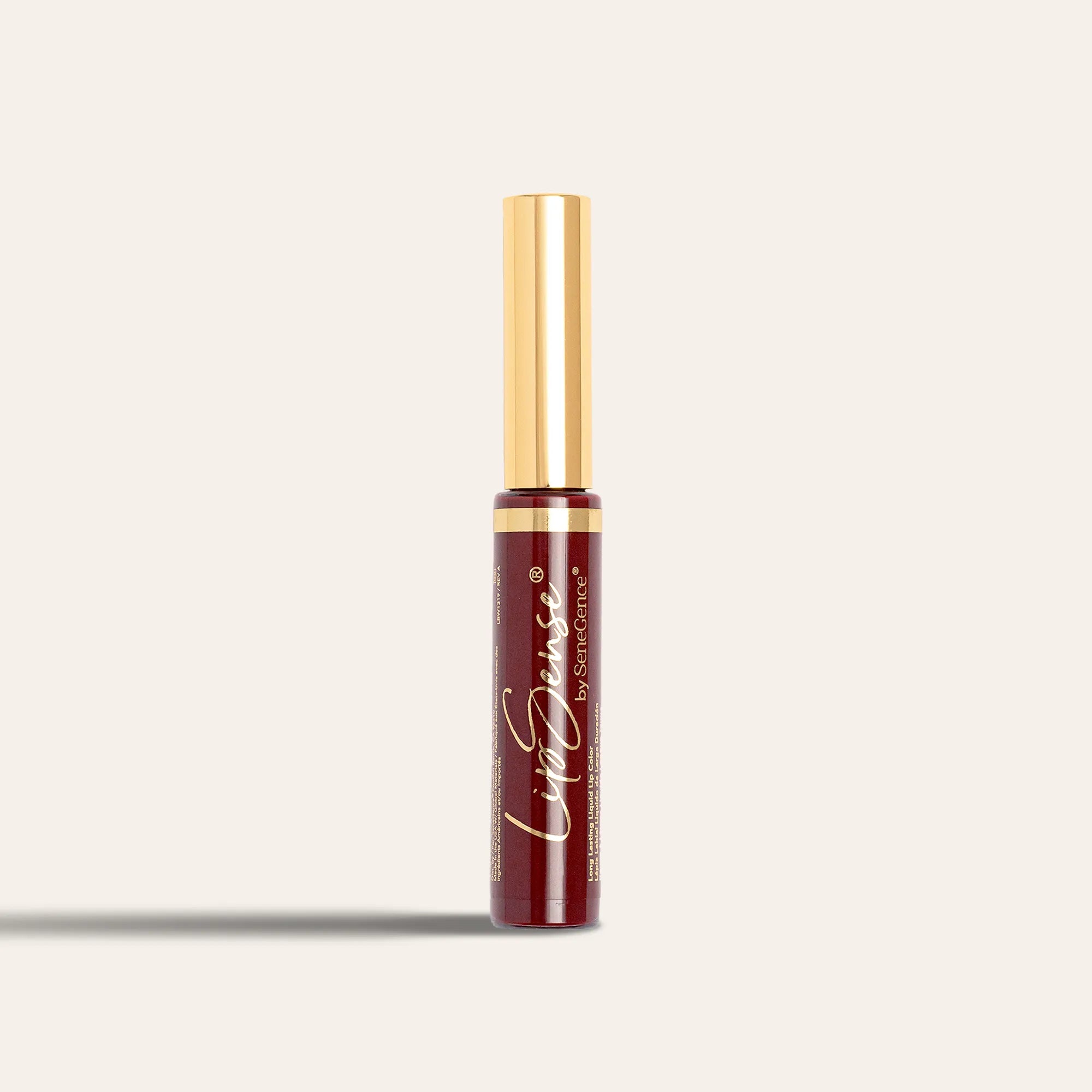 A current LipSense® Lip Color tube in a deep plum shade with a gold cap, photographed against a pale background.