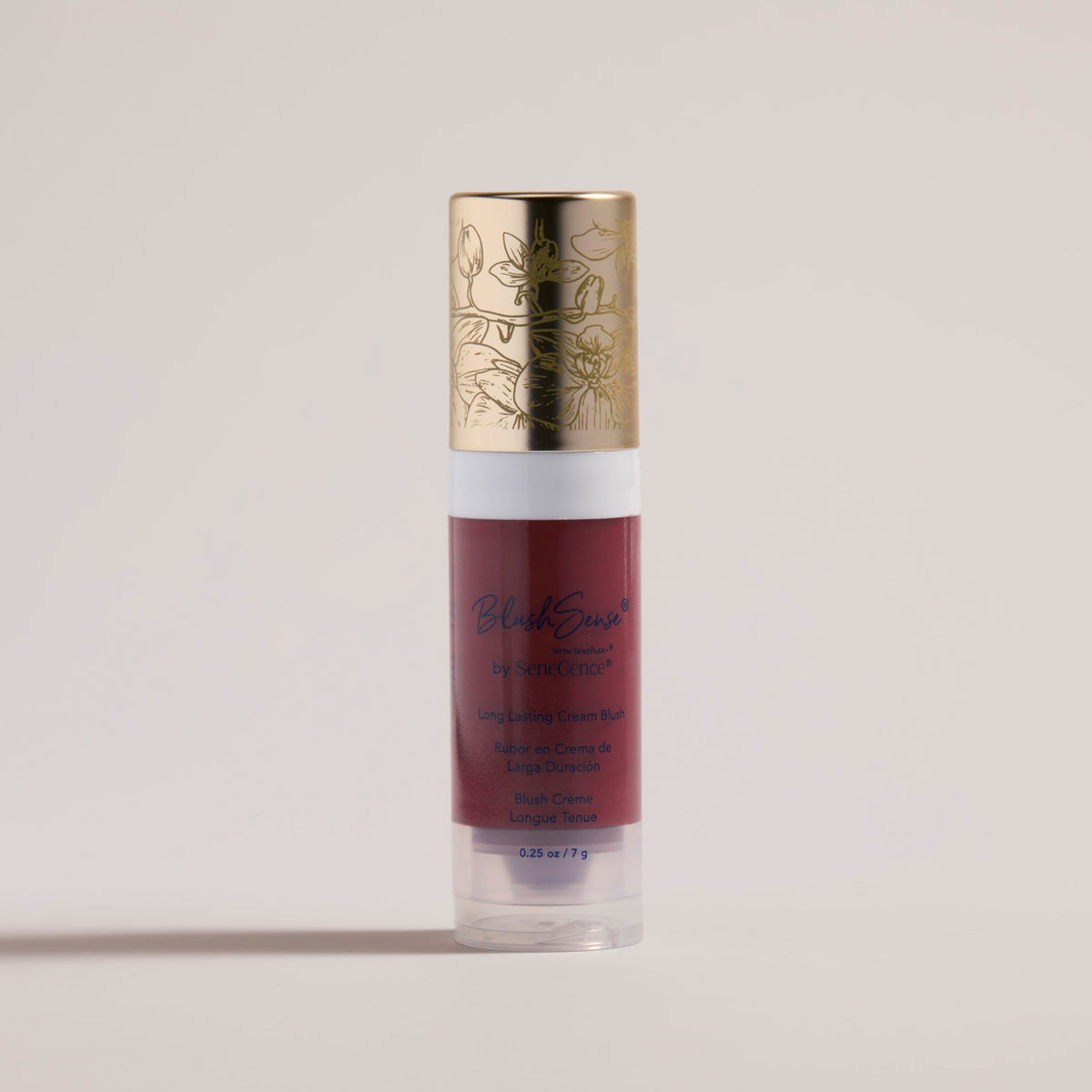 A clear tube of deep berry-red cream blush with a white collar and an orchid-engraved gold cap, BlushSense® Cream Blush.