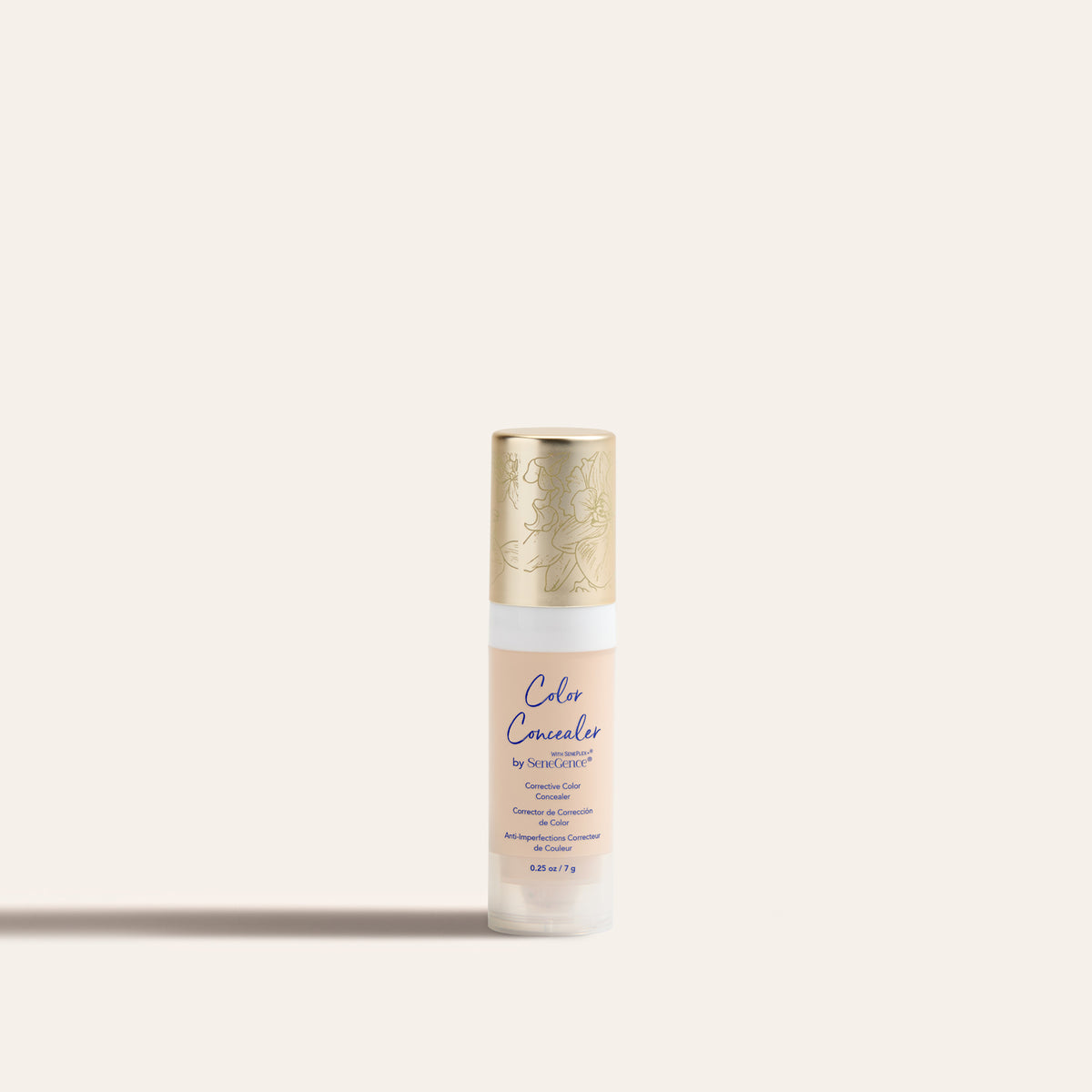 A small pale concealer tube with a gold orchid-engraved cap, Corrective Color Concealer.