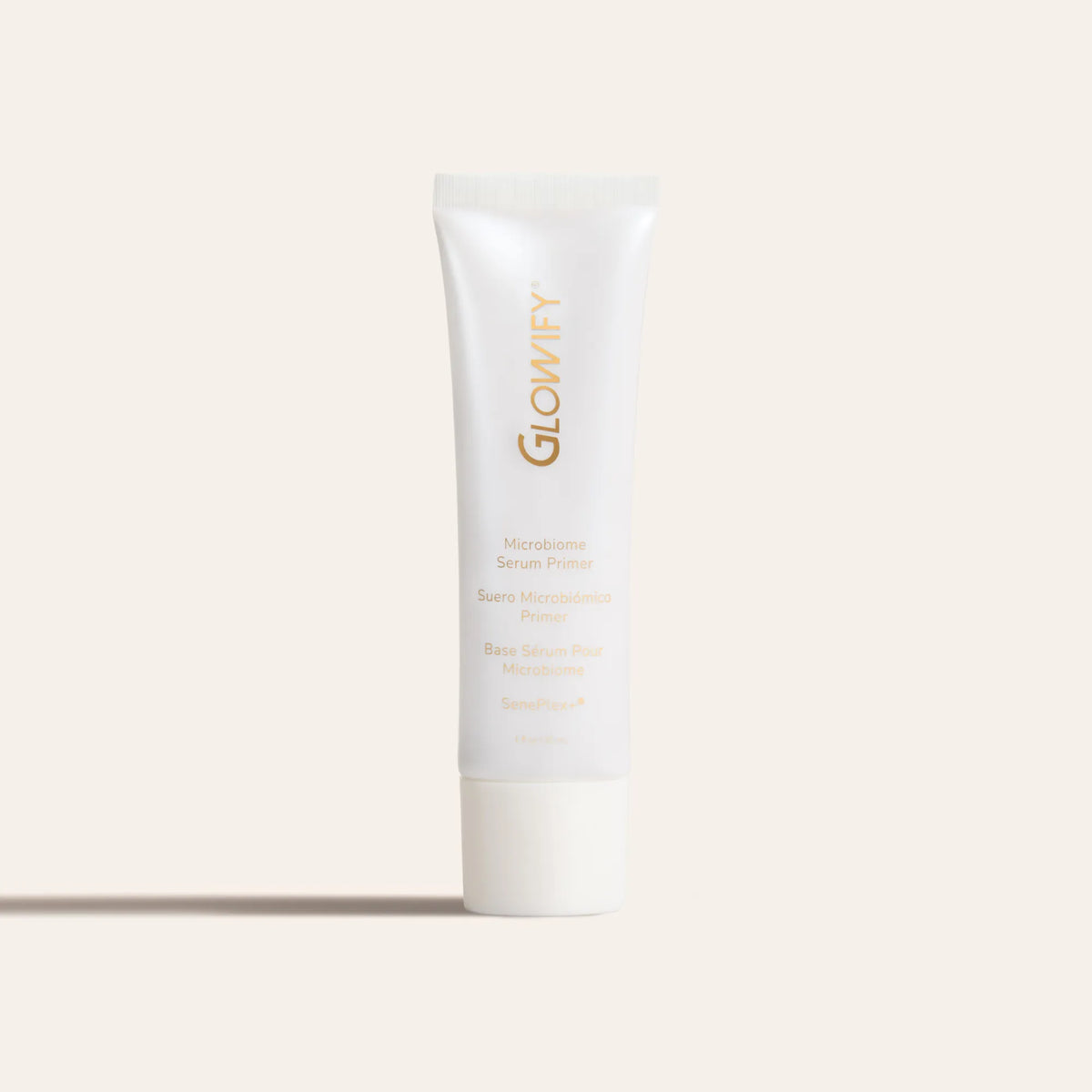 A white primer tube with gold lettering, Glowify® Microbiome Serum Primer.
