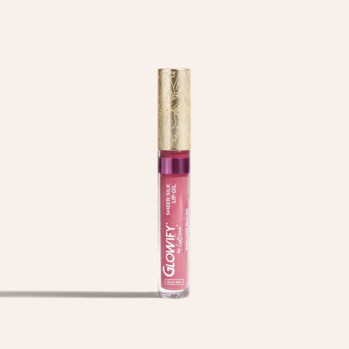 A clear tube of pink lip oil with an orchid-engraved gold cap, Glowify Sheer Silk Lip Oil.