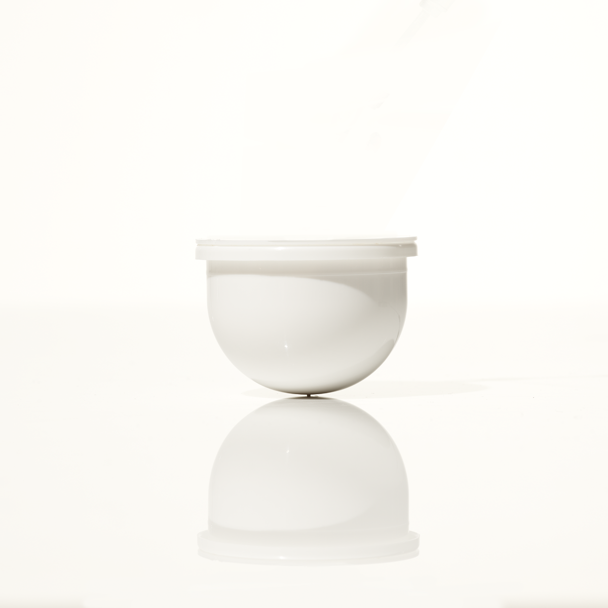 A white round moisturizer refill pod, Microbiome Restorative Evening Moisturizer Refill Pod.
