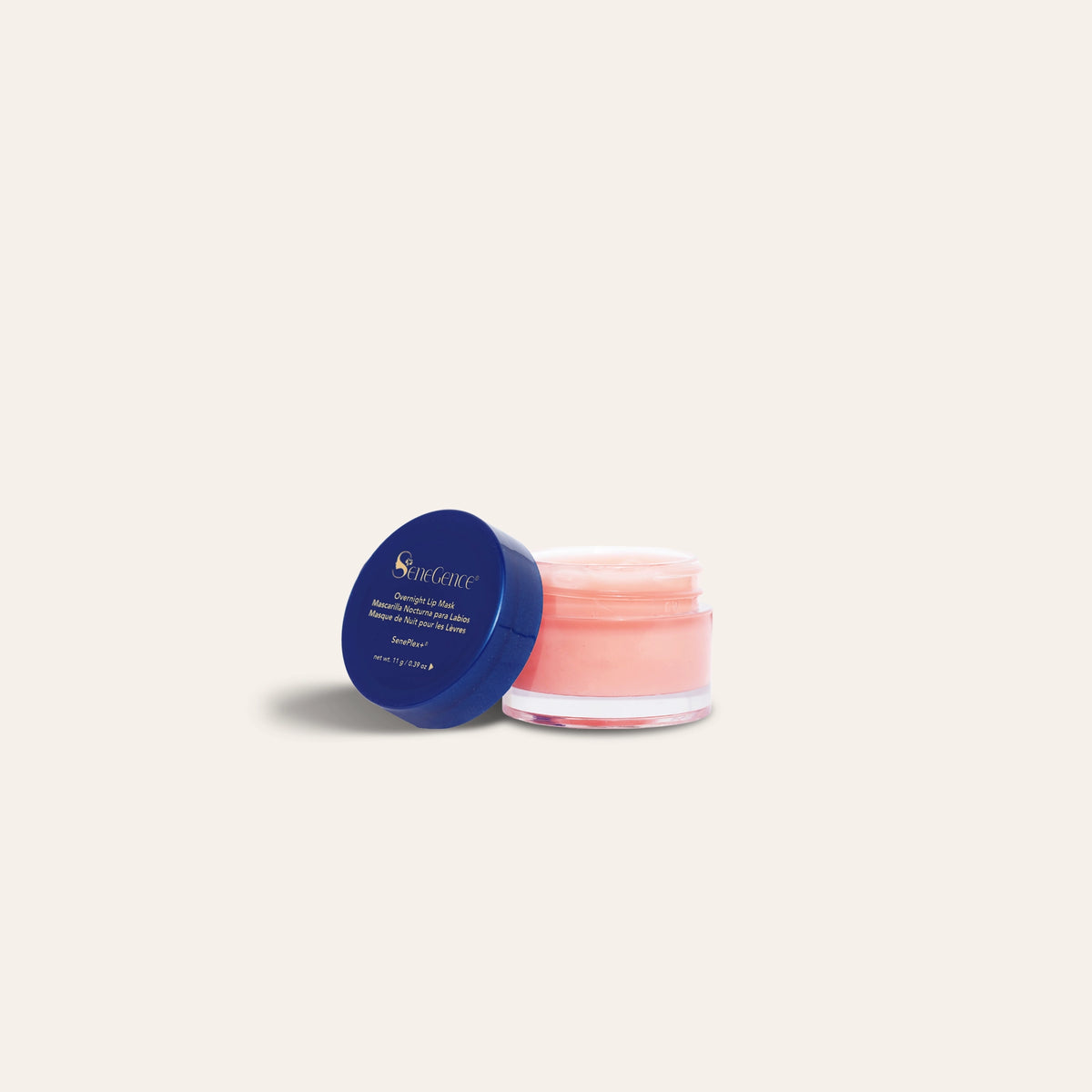 An open pot of pink lip mask beside a blue lid, Overnight Lip Mask.
