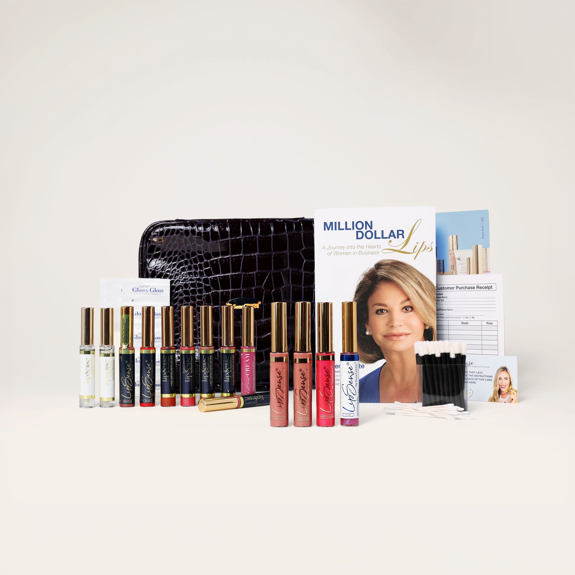 LipSense® lip colors and glosses, a black croc-textured SeneGence bag, the Million Dollar Lips book, a Beauty Book catalogue, customer receipts and applicators from the Lips Kit.